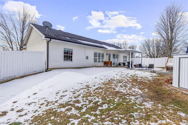 snow covered rear of property with fence and a pergola