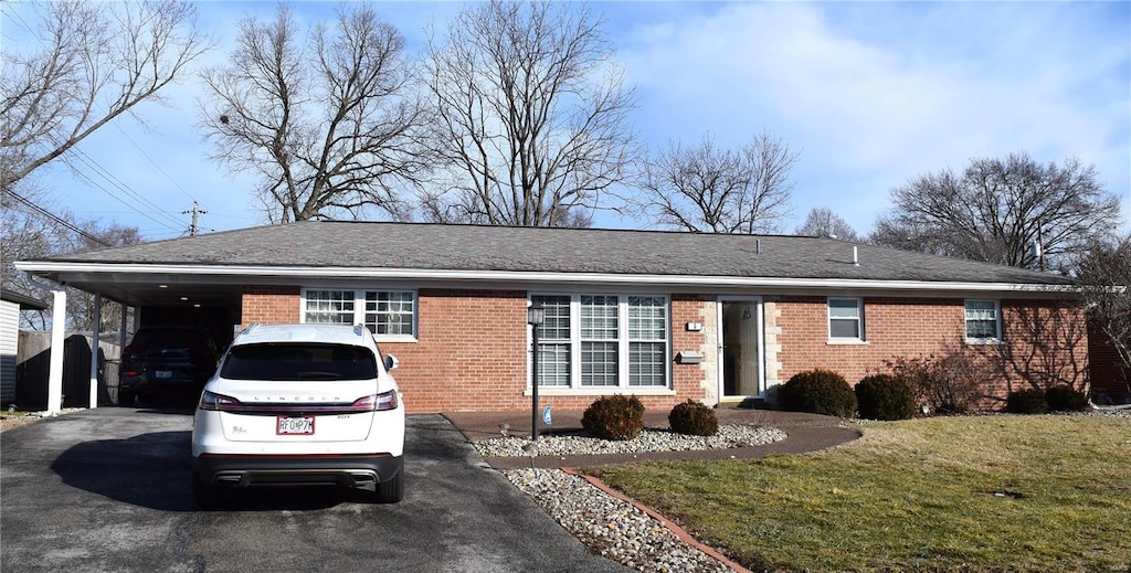 ranch-style home with a front lawn and a carport