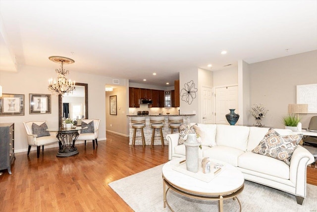 living room featuring a chandelier and light hardwood / wood-style flooring