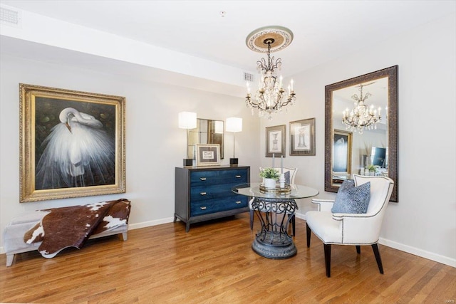 sitting room featuring a chandelier and light hardwood / wood-style flooring