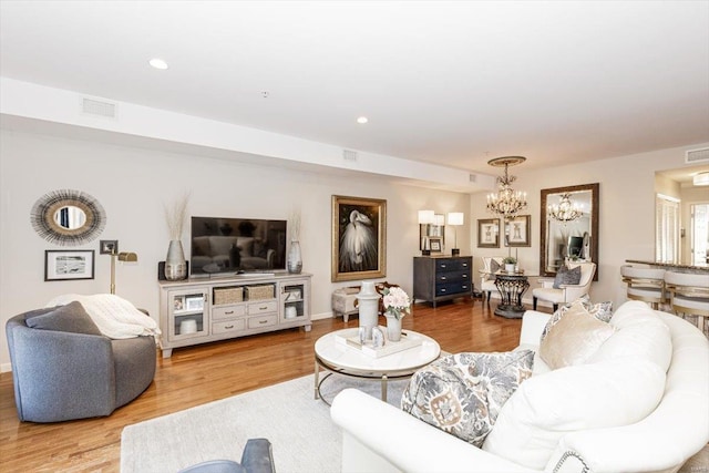 living room with wood-type flooring and an inviting chandelier