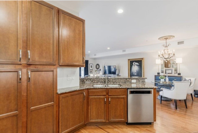 kitchen with sink, stainless steel dishwasher, light hardwood / wood-style floors, and light stone countertops