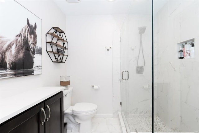 bathroom featuring toilet, vanity, and a shower with shower door