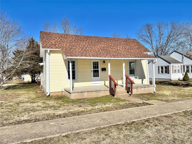 bungalow with a front lawn and covered porch