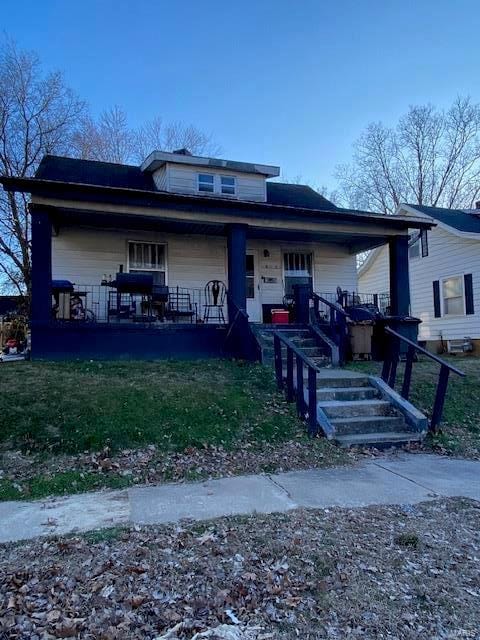 view of front of home with a front yard and covered porch