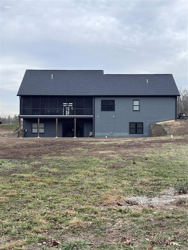 back of property featuring a sunroom and a lawn