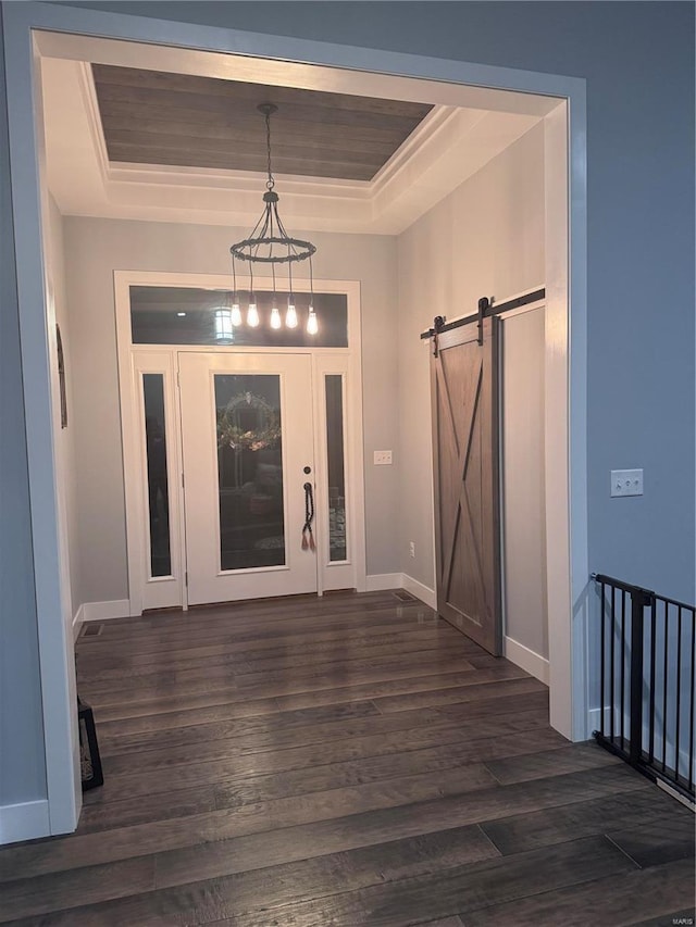 entryway featuring dark hardwood / wood-style floors, a barn door, and a raised ceiling