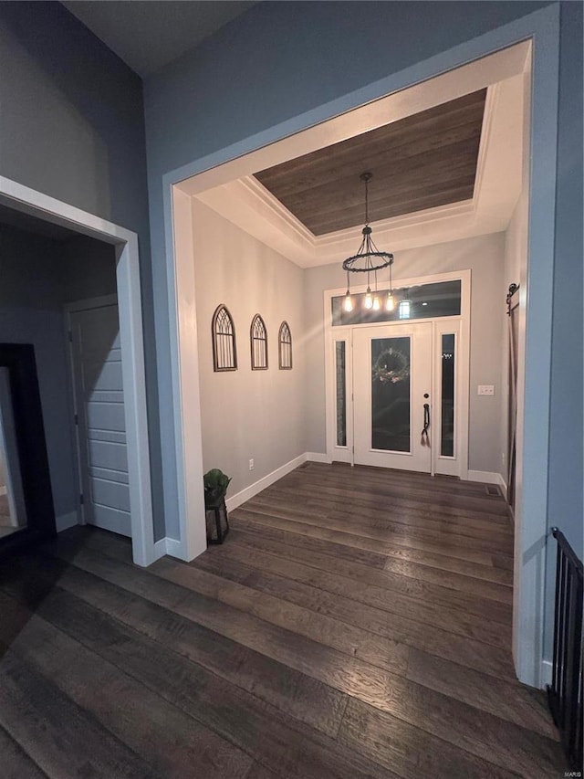 interior space with dark hardwood / wood-style floors and a raised ceiling