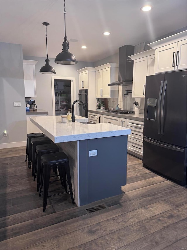 kitchen featuring white cabinets, decorative light fixtures, and black appliances