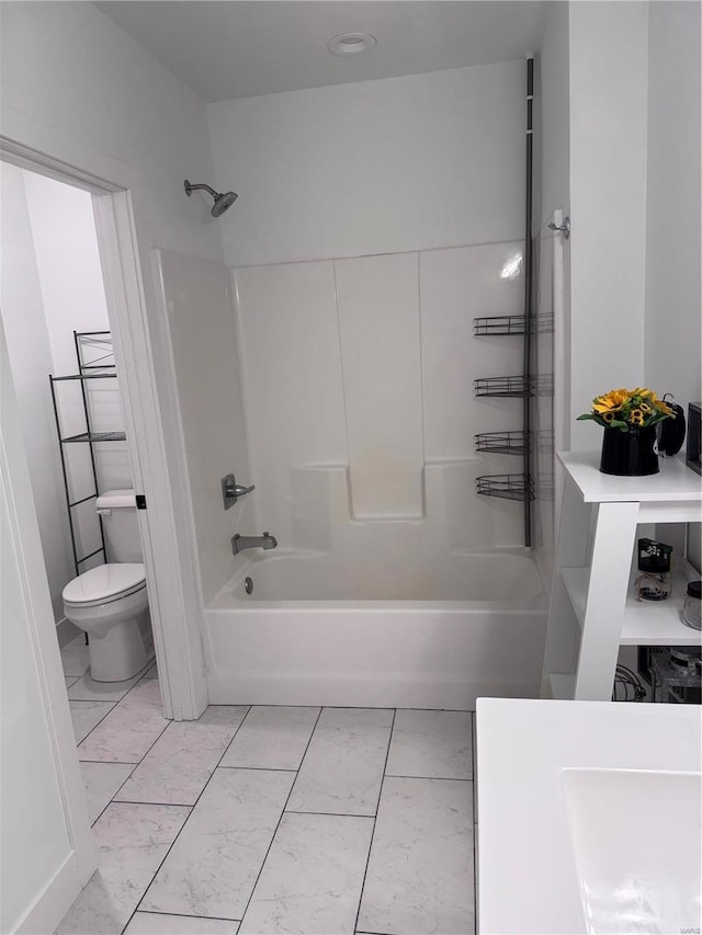 bathroom featuring washtub / shower combination and toilet