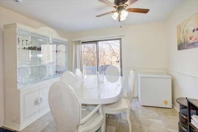 dining space with light tile patterned floors and a ceiling fan