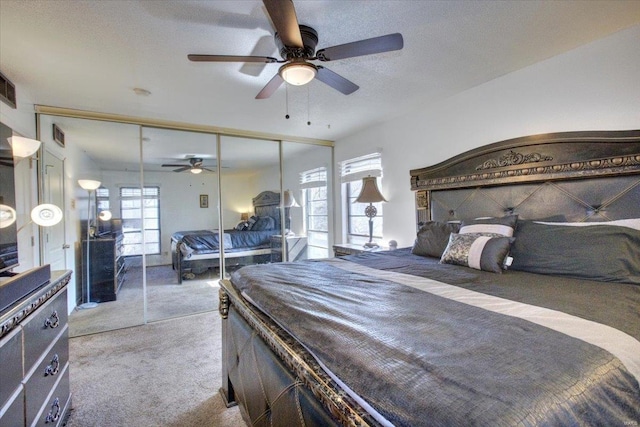 bedroom featuring a textured ceiling, multiple windows, carpet flooring, and visible vents