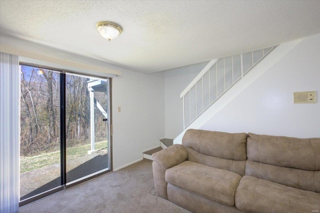 carpeted living room with a textured ceiling, stairway, and baseboards