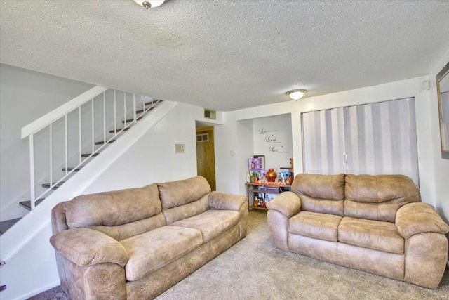 carpeted living area featuring a textured ceiling, stairway, and visible vents