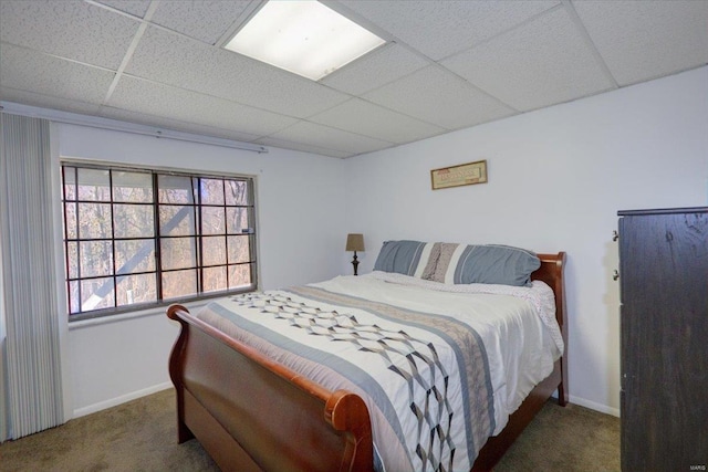 bedroom featuring a paneled ceiling, carpet flooring, and baseboards