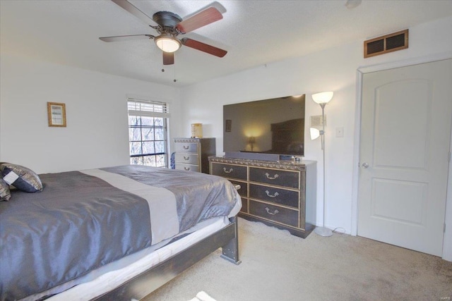 bedroom with a ceiling fan, visible vents, and light colored carpet