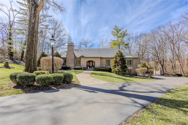 view of front of property featuring a front lawn and a chimney