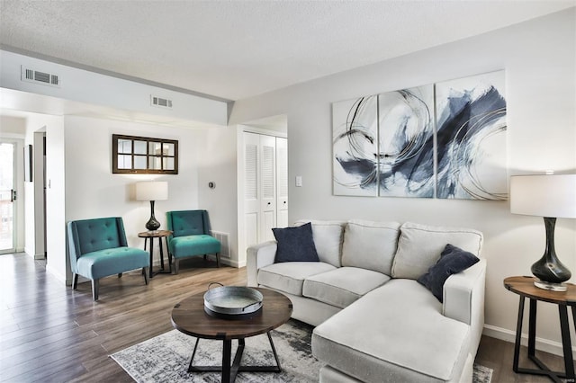 living room with wood-type flooring, a textured ceiling, and plenty of natural light