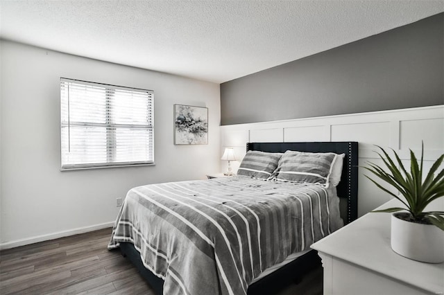 bedroom with dark wood-type flooring and a textured ceiling