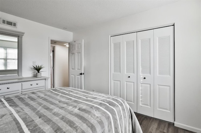 bedroom featuring dark hardwood / wood-style flooring, a closet, and a textured ceiling