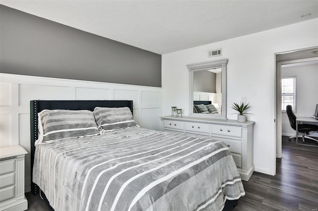 bedroom with dark wood-type flooring and a textured ceiling