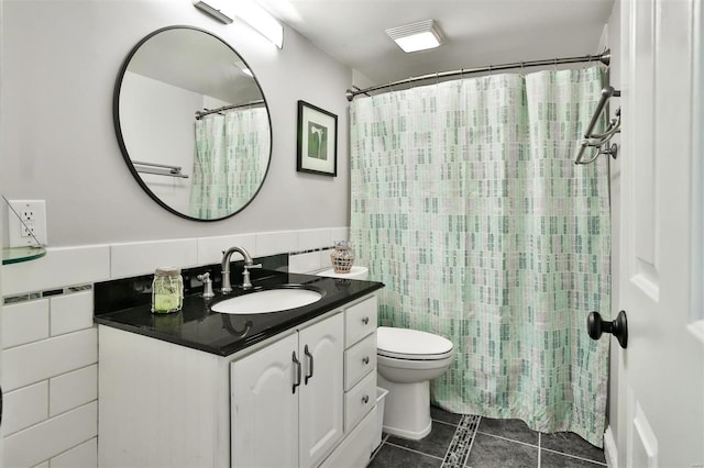 bathroom featuring tile walls, vanity, tile patterned floors, and toilet