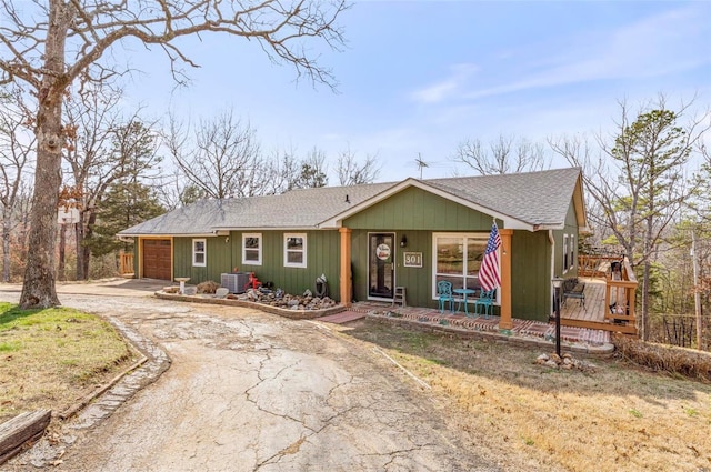 single story home featuring a garage and central air condition unit