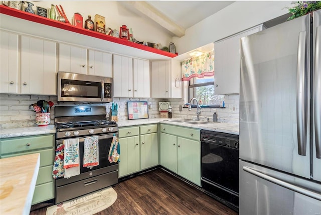 kitchen with stainless steel appliances, sink, green cabinets, and white cabinets