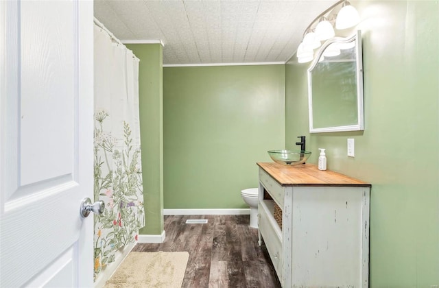 bathroom featuring hardwood / wood-style flooring, vanity, ornamental molding, and toilet