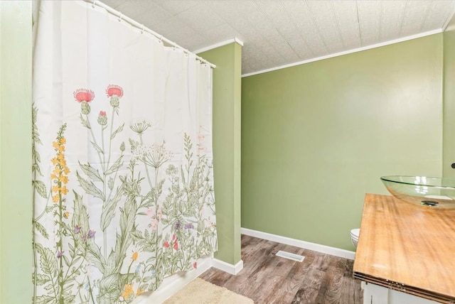 bathroom featuring crown molding, vanity, toilet, and hardwood / wood-style flooring