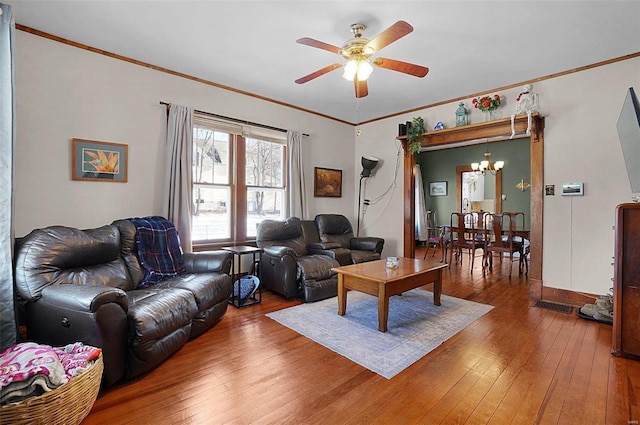 living room with hardwood / wood-style floors, ceiling fan with notable chandelier, and ornamental molding