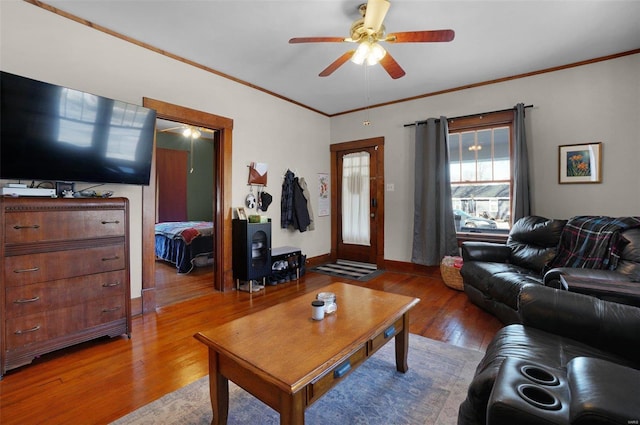 living room featuring hardwood / wood-style flooring, crown molding, and ceiling fan