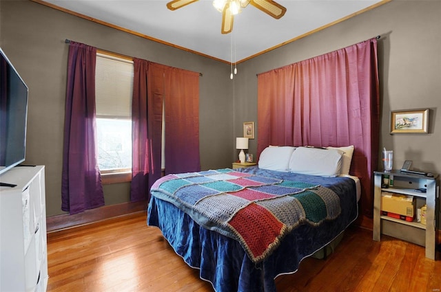 bedroom featuring ceiling fan, ornamental molding, and hardwood / wood-style floors