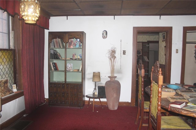 interior space featuring a paneled ceiling and a notable chandelier