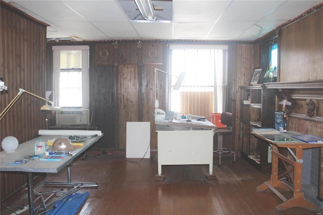 office space with a drop ceiling, dark hardwood / wood-style flooring, and wood walls