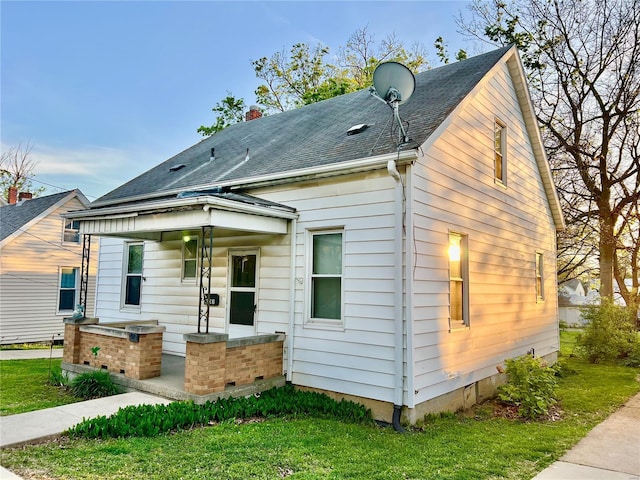 view of front of property featuring roof with shingles and a front lawn