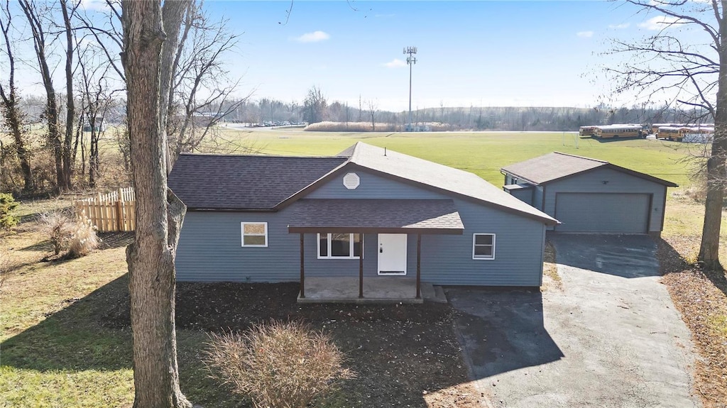 view of front of home with a garage, a patio, an outbuilding, and a front lawn