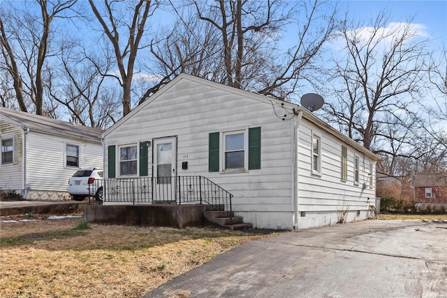 bungalow-style house featuring a front lawn