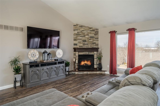 living room featuring a stone fireplace, vaulted ceiling, and dark hardwood / wood-style floors