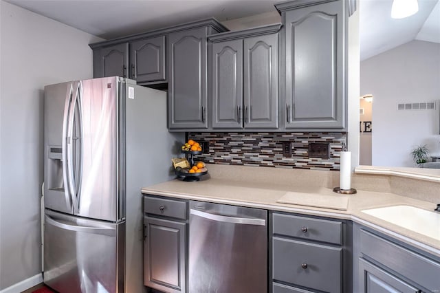 kitchen with appliances with stainless steel finishes, decorative backsplash, and gray cabinetry