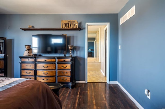 bedroom with dark hardwood / wood-style flooring