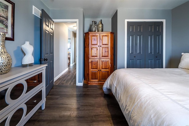 bedroom with dark wood-type flooring and a closet