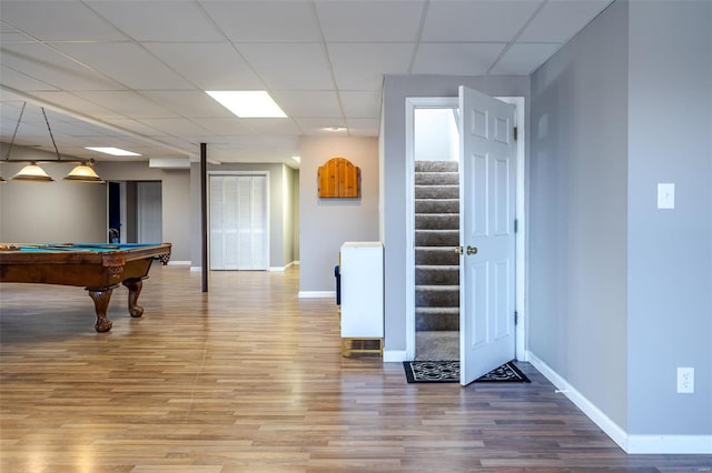 rec room with a paneled ceiling, hardwood / wood-style floors, and billiards