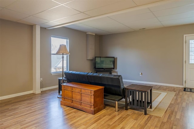 interior space with a paneled ceiling and light hardwood / wood-style flooring