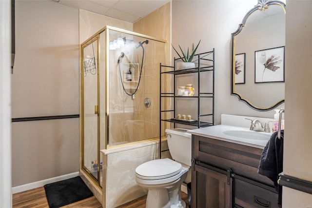 bathroom featuring hardwood / wood-style flooring, vanity, toilet, and a shower with shower door