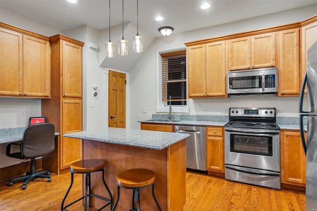 kitchen with light stone countertops, a kitchen bar, stainless steel appliances, and a kitchen island