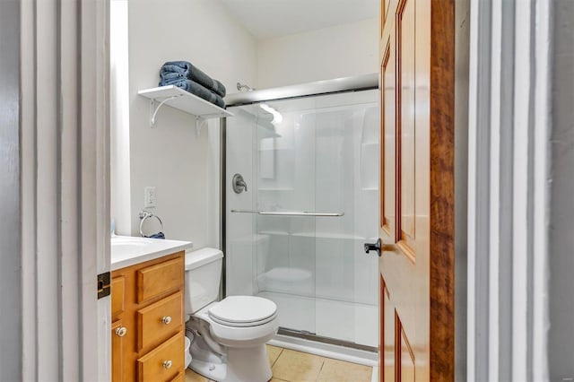 bathroom with vanity, a shower with shower door, tile patterned floors, and toilet