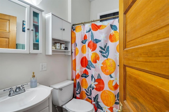 bathroom featuring a shower with curtain, vanity, and toilet