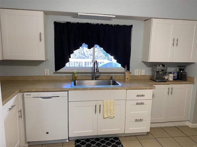 kitchen with white dishwasher, sink, white cabinetry, and light tile patterned flooring