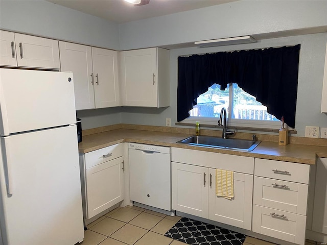 kitchen with sink, white appliances, light tile patterned floors, and white cabinets